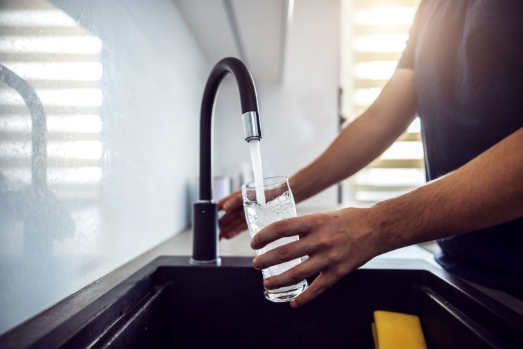 man filling water from tap after changing business water supplier