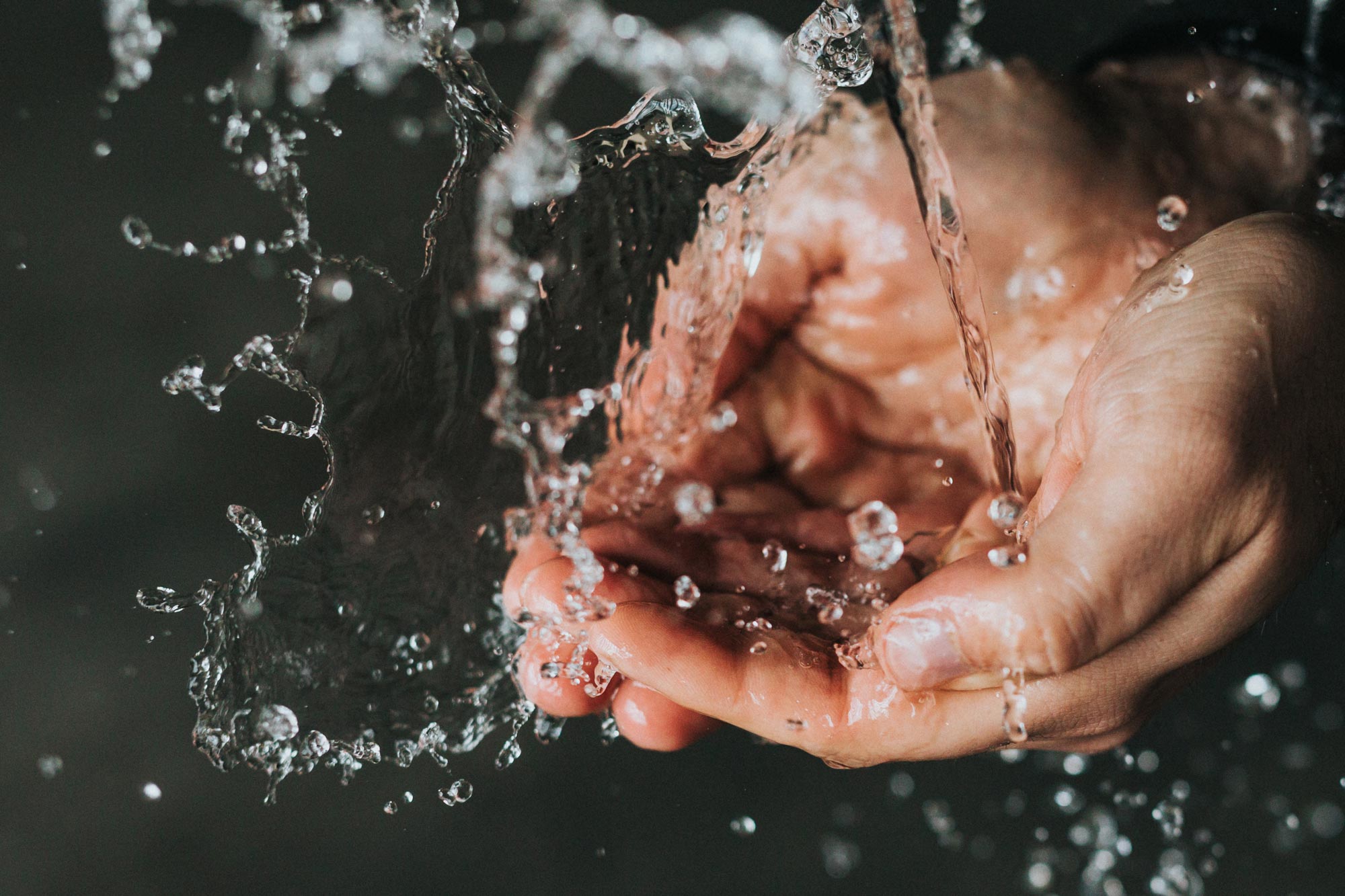 A person washing their hands using their water utilities