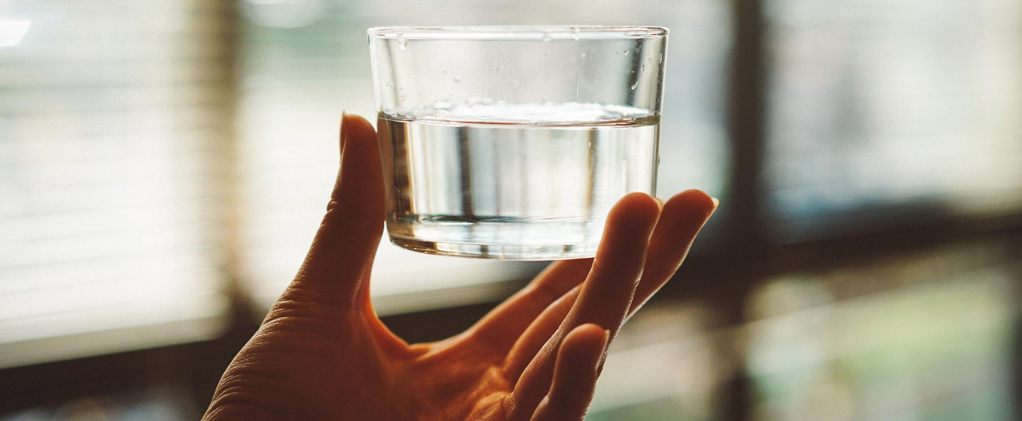 A person holding a cup of water